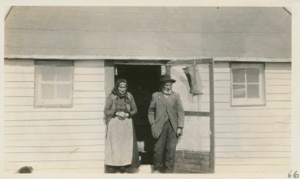 Image of Elderly couple by doorway. Boots hanging on screen door